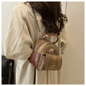 Detail of vintage brown mini backpack featuring cat print and elegant gold chain strap
