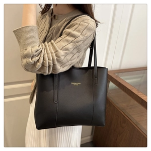 Detail of black leather tote bag featuring gold FASHION & BAGS LEATHER lettering