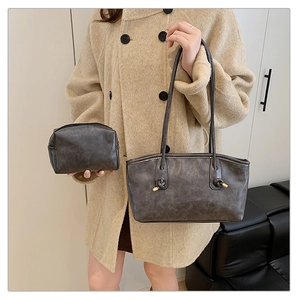 Detail of dark grey tote bag with knot strap and matching small pouch for daily commute