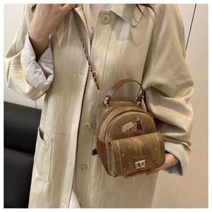 Mini brown backpack bag with cute cat prints and chain strap shown on a beige trench coat