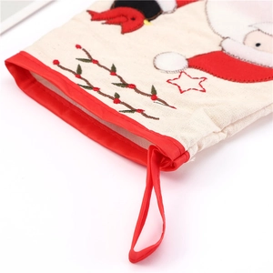 Detail of embroidered Christmas stocking top with red hanging loop and festive berry motif