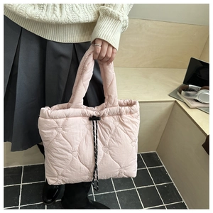 Detail showing heart-shaped quilted pattern and drawstring closure on pink tote bag