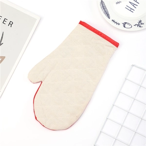 Close-up of quilted cotton Christmas oven mitt with heat-resistant red trim detail