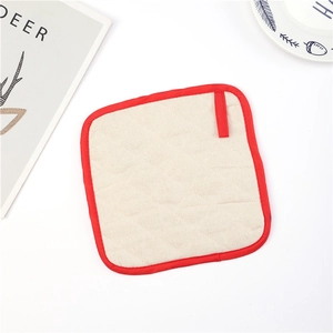Close-up of diamond quilted cotton pot holder with red piping and hanging loop