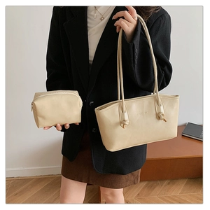 Detail view of beige tote bag with soft PU leather texture and matching inner pouch