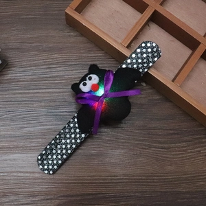 Detail showing glowing LED bat plush snap bracelet with purple bow and silver sequins