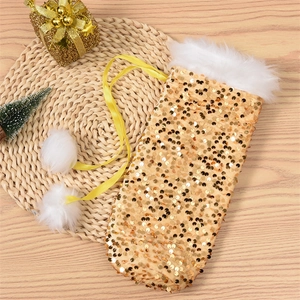 Detail of sequined gold Christmas bottle cover with white faux fur and pom-poms