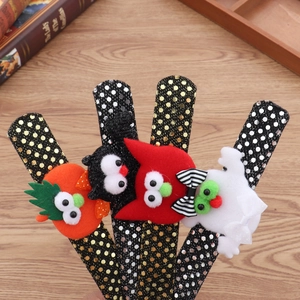 Close-up of Halloween plush wristbands with pumpkin, cat, and ghost 3D googly eye details