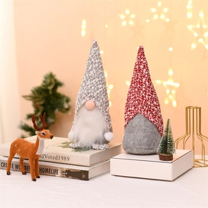 Close-up of plush Christmas gnomes with floral hats and white beards in a festive setting