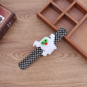 Detail of Halloween slap bracelet featuring white plush ghost on black polka dot fabric