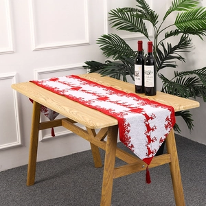 Christmas knitted table runner with reindeer pattern and red tassels for festive dining decor