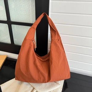 Modieuze hobo schoudertas van oranje nylon voor dames op getextureerde achtergrond