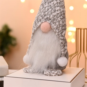 Close-up of Christmas gnome plush with grey knitted hat and soft white faux fur beard