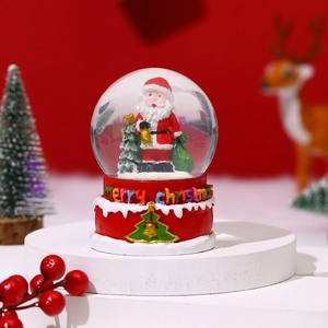 Detail of Santa Claus snow globe with music and floating snow on red festive base