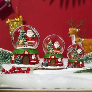 Three-piece set of Christmas snow globes with Santa and tree inside house-shaped bases