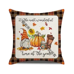 Detail of autumn gnome and pumpkin print on a plaid-edged square linen cushion cover