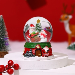 Christmas musical snow globe with Santa and snowman on a festive red house base