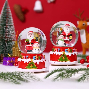 Close-up of musical Christmas snow globe featuring Santa Claus and snowman miniatures