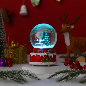 Detail of Christmas snow globe with Santa, glowing blue light, and red festive base