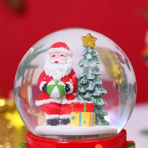 Detail of Christmas snow globe with Santa Claus, Xmas tree and festive red base