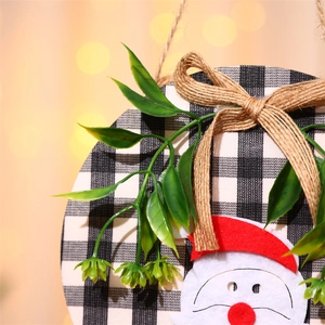 Detail eines Weihnachts-Türschilds aus Holz mit Weihnachtsmann und Karomuster