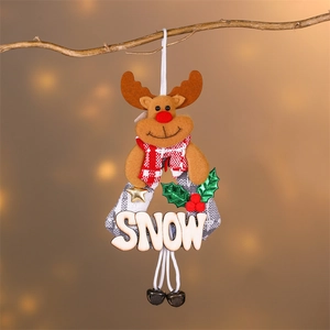 Detail of felt reindeer ornament with SNOW wooden plaque and bells on a winter branch