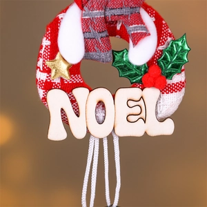 Close-up of Noel wooden pendant with fabric wreath, gold star and holly leaves decoration