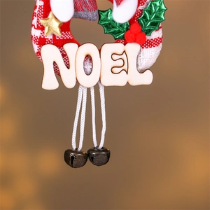 Detail of wooden Noel sign with holiday ornaments and vintage metal bells on string