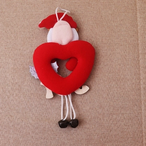 Detail of Christmas plush gnome hanging with hollow red heart and wooden base