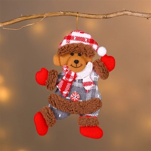 Détail d'un ours en peluche de Noël avec chapeau à carreaux suspendu à une branche