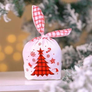 Close-up of drawstring Christmas gift bag with red plaid tree and cute rabbit ear ties