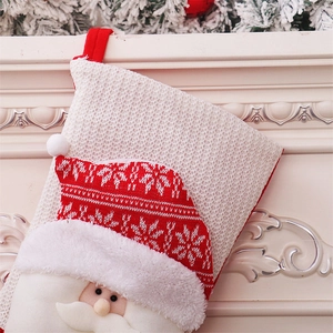Detailed knit Christmas stocking with a 3D Santa Claus applique and plush beard hanging