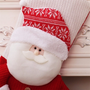 Detail of red knitted Christmas stocking featuring a 3D Santa Claus and wooden button