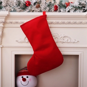 Detail of red Christmas stocking hanging on a white fireplace with festive pine decorations