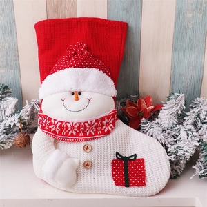 Detail of a large knitted Christmas stocking featuring a 3D snowman with a red gift box