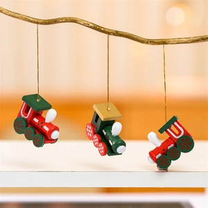 Détail de trois ornements de train de Noël en bois suspendus sur une branche d'arbre