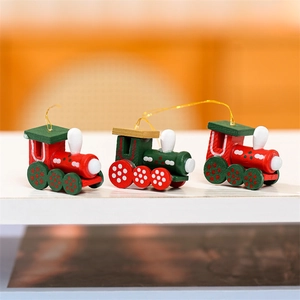 Détail de trois mini ornements de train de Noël en bois avec peinture rouge et verte festive
