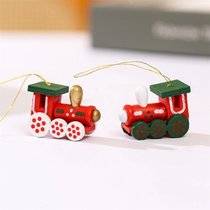 Vue macro de deux petits trains de Noël en bois, coloris rouge, vert et blanc