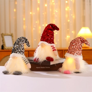 Three glowing Christmas gnomes with sequined hats and LED warm lights on books