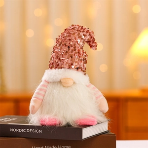 Close-up of pink sequined Christmas gnome plush with long white beard on Nordic books