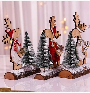 Détail de trois rennes en bois artisanaux avec bonnets, écharpes et mini sapins de Noël