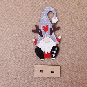 Close-up of a Christmas gnome wooden ornament with reindeer antlers and Welcome text