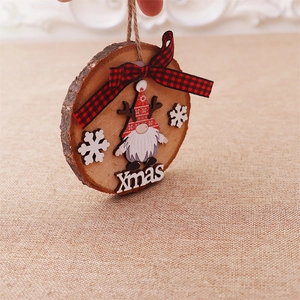 Detail of round wooden gnome ornament with red plaid bow and Xmas lettering decor