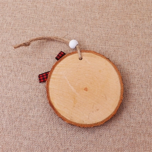 Macro shot of rustic round wooden Christmas ornament with burlap ribbon and bead detail