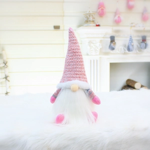 Detailed close-up of pink knit gnome hat with sequins on a soft white plush rug