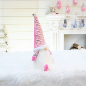 Detail of pink knitted gnome plush with sequined hat and white beard for Christmas decor