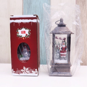 Macro view of Christmas LED lantern with Santa Claus figurine and original packaging box