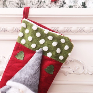 Close-up of a large Christmas stocking with a gnome and tree hanging on a white fireplace