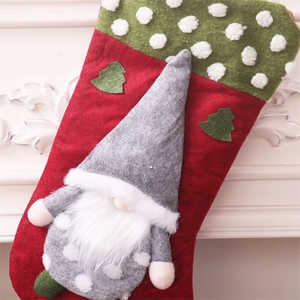 Detail of a red Christmas stocking featuring a 3D gnome doll on a white fireplace mantel