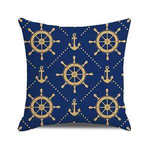 Détail d'une housse de coussin nautique avec motifs d'ancre et de barre dorés sur bleu marine